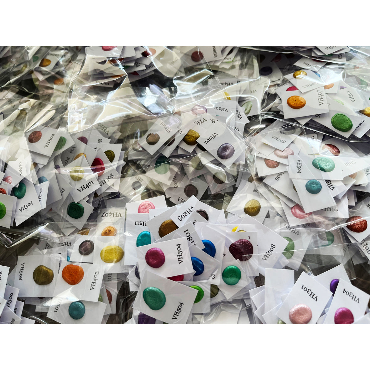 Viele handverpackte Dotkarten mit schimmernden Metallic-Aquarellfarben – Probensets in Einzeltütchen mit Farbnamen